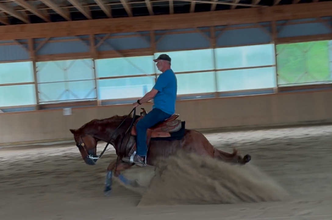 Sliding stop kicking up arena sand